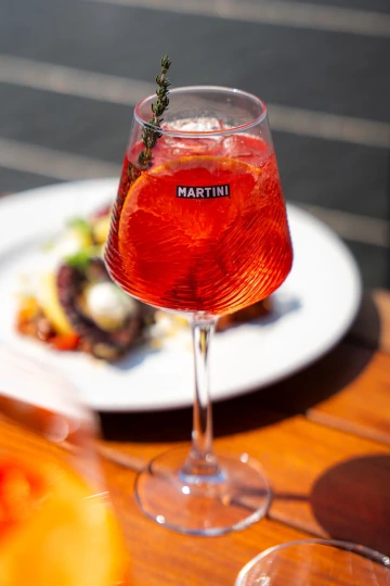 Aperol Spritz in a chilled glass on a restaurant table.