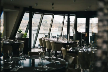 Elegantní interiér Marina Ristorante s panoramatickými okny nad Vltavou.