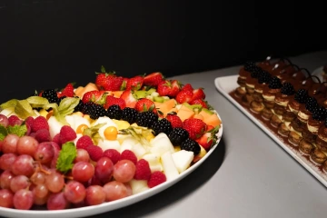 Fruit platter with grapes and strawberries beside tiramisu.