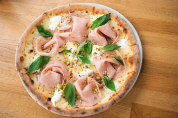Vychutnejte si pizzu s mortadellou, pistáciemi a bazalkou. Dokonalá chuť, která vás okouzlí. Zažijte italskou vášeň u nás.