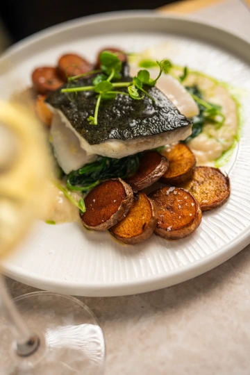 Rybí filet s opečenými bramborami a hráškovým pyré.